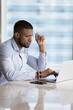 © fizkes - Focused busy millennial Black business leader man typing on laptop at office workplace, using app for Internet communication, job task completing, working at computer. Vertical shot
