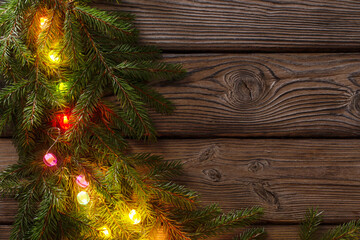 Wall Mural - colorful christmas lights on dark wooden background