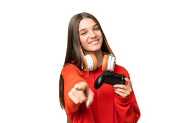 Poster - Teenager caucasian girl playing with a video game controller over isolated background pointing front with happy expression