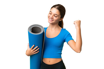 Sticker - Teenager caucasian girl going to yoga classes while holding a mat over isolated background celebrating a victory