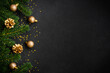 Christmas flat lay background with golden holiday decorations on black. Top view with copy space.