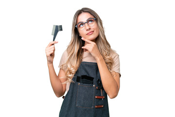 Wall Mural - Young Uruguayan hairdresser woman over isolated background having doubts while looking up