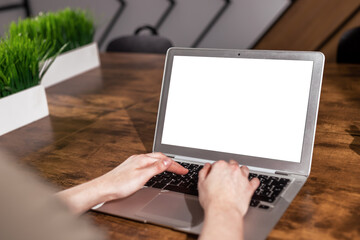 Poster - Laptop screen mockup and hand typing. Computer display mock up with white blank background on wood office desk