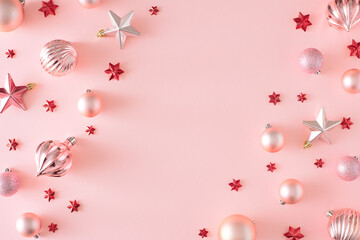 Wall Mural - Christmas eve concept. Top view photo of Christmas baubles and stars on pastel pink background with copy space. Winter holiday card idea.