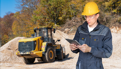 Aufkleber - Engineer in a helmet with a digital tablet on the background of construction machine	