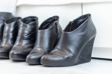 three pairs of black boots with high heels in front of a white closet