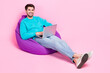 © deagreez - Full length photo of handsome young guy sit bean bag working remotely coder wear trendy blue clothes isolated on pink color background