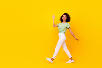 Canvas Print - Full body size attractive adorable gorgeous nice woman wear green t-shirt white pants showing hello palm positive isolated on yellow color background