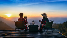 Romantic Couple Camping Outdoors And Taking Photos With Camera While Camping At Sunrise. Doi Luang Chiang Dao Mountains In Chiang Mai.