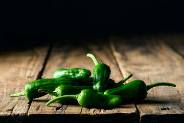 Padron peppers on a wooden table, dark food