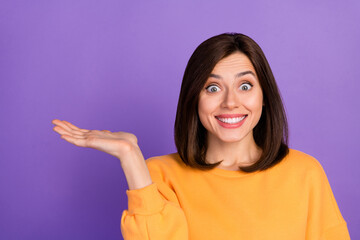 Sticker - Closeup photo of young millennial cute pretty lady wear orange shirt toothy smile excited hold palm recommend promo product isolated on purple color background