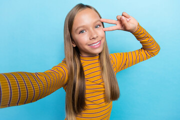 Canvas Print - Portrait of positive friendly person take selfie demonstrate v-sign near eye isolated on blue color background