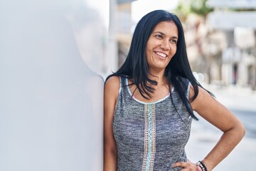 Wall Mural - Middle age hispanic woman smiling confident looking to the side at street