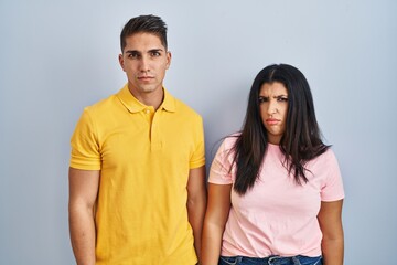 Sticker - Young couple standing over isolated background skeptic and nervous, frowning upset because of problem. negative person.