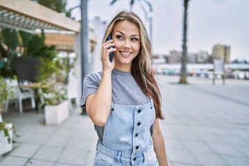 Young caucasian girl smiling happy talking on the smartphone at the city.