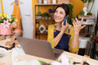© Krakenimages.com - Middle age hispanic woman florist talking on smartphone using laptop at flower shop