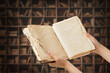 Woman with old old book in library, closeup