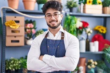 Canvas Print - Young hispanic man florist smiling confident standing with arms crossed gesture at florist shop