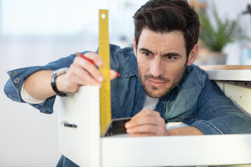 man assembling diy furniture at home