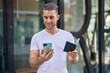 © Krakenimages.com - Young caucasian man using smartphone holding passport at street