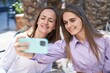 © Krakenimages.com - Two women mother and daughter make selfie by smartphone sitting on table at coffee shop terrace