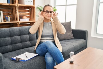 Canvas Print - Young woman working at consultation office trying to hear both hands on ear gesture, curious for gossip. hearing problem, deaf