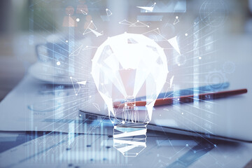 Poster - Computer on desktop in office with bulb icon hologram. Double exposure. Concept of idea.