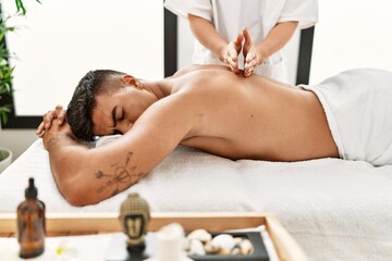 Poster - Young hispanic man relaxed having back massage at beauty center