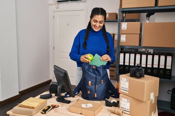 Poster - Young hispanic woman ecommerce business worker prepare backpack at office