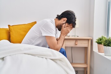 Canvas Print - Young hispanic man sitting on bed crying at bedroom