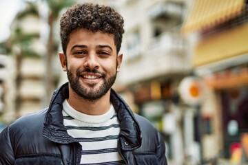 Canvas Print - Young arab man smiling outdoor at the town