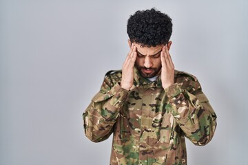 Poster - Arab man wearing camouflage army uniform with hand on head, headache because stress. suffering migraine.