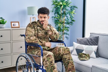 Sticker - Arab man wearing camouflage army uniform sitting on wheelchair looking stressed and nervous with hands on mouth biting nails. anxiety problem.