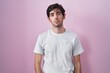 © Krakenimages.com - Young hispanic man standing over pink background depressed and worry for distress, crying angry and afraid. sad expression.