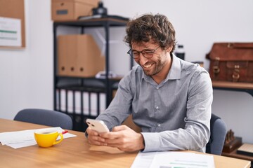 Sticker - Young hispanic man business worker using smartphone working at office