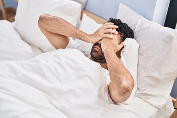 Wall Mural - Young hispanic man suffering for insomnia lying on bed at bedroom