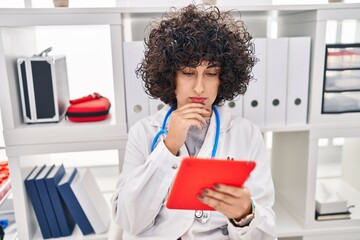 Wall Mural - Young middle east woman wearing doctor uniform using touchpad at clinic