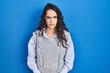 © Krakenimages.com - Young brunette woman standing over blue background skeptic and nervous, frowning upset because of problem. negative person.