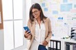 © Krakenimages.com - Young beautiful hispanic woman business worker smiling confident using smartphone at office