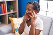 © Krakenimages.com - Middle age african american woman talking on smartphone with worried expression at home