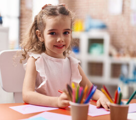 Poster - Adorable caucasian girl playing with construction blocks sitting on table at classroom