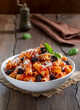 © Iryna - Pasta Alla Norma. Delicious Sicilian pasta dish with roasted eggplant, marinara tomato sauce, grated ricotta and fresh basil served in a white ceramic bowl. Wooden table, selective focus, vertical.