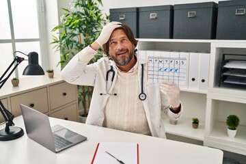 Canvas Print - Handsome middle age doctor man holding holidays calendar stressed and frustrated with hand on head, surprised and angry face