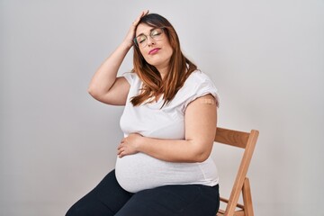 Wall Mural - Pregnant woman wearing band aid for vaccine injection stressed and frustrated with hand on head, surprised and angry face