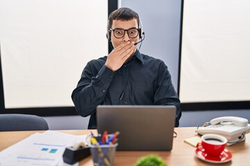 Poster - Young arab man wearing call center agent headset covering mouth with hand, shocked and afraid for mistake. surprised expression