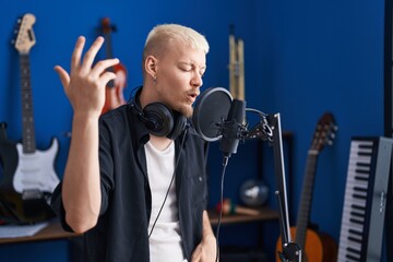 Wall Mural - Young caucasian man artist singing song at music studio