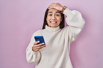 Wall Mural - Young south asian woman using smartphone stressed and frustrated with hand on head, surprised and angry face