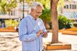 © Krakenimages.com - Senior man smiling confident using smartphone at park