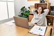 © Krakenimages.com - Brunette woman with down syndrome stretching arms relaxing at business office