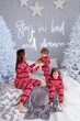 © Olena - People in same family look red pajamas playing at home in christmas day. Happy funny kids daughter, son with mother spend time, enjoying being together in decorated winter bedroom. New Year holidays